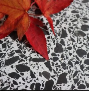 terrazzoa-piano avec un fond gris et des pierres noires
